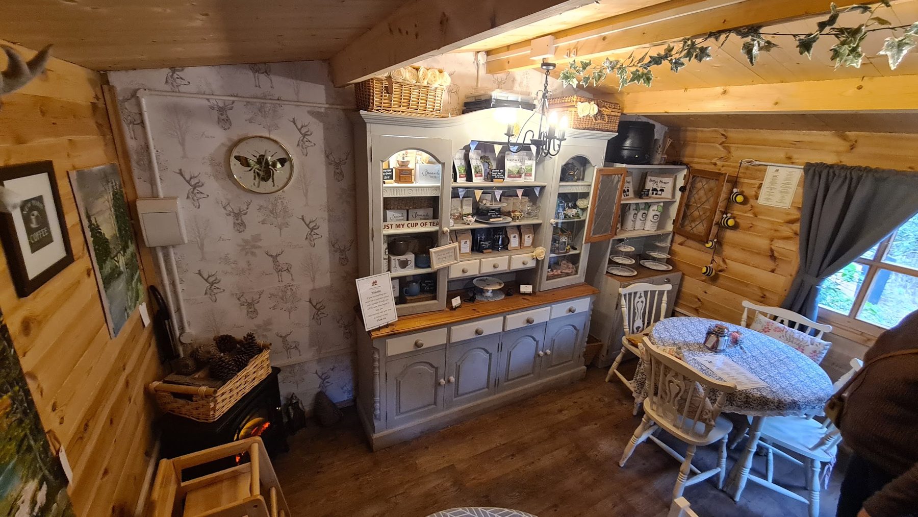 Inside the wooden tea room, with a dresser, framed pictures and a small table